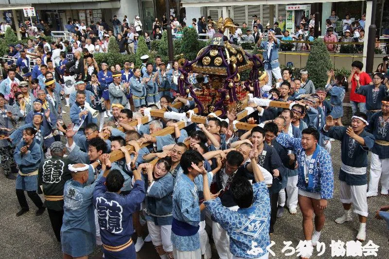 Fukuro Matsuri mikoshi procession passing spectators along streets near Ikebukuro West Exit