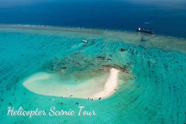 Aerial view of Phantom Island and the Sekisei Lagoon from an Ishigaki helicopter. The 10-minute route is about seeing sandbar and reef geometry from above.