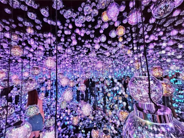 Bubble Universe at teamLab Borderless with glowing spheres reflected through a mirrored immersive room