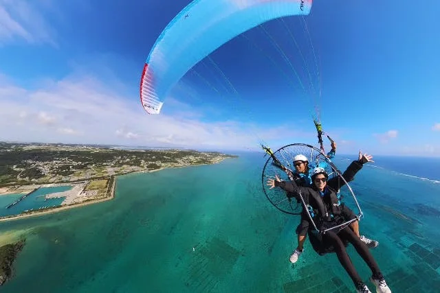 Tandem powered paragliding in Okinawa. The premium is for an independent land-launched flight, not simply a few extra airborne minutes.