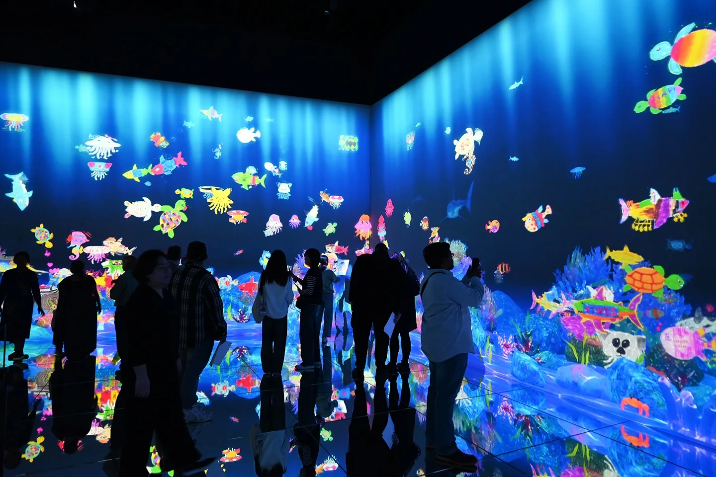 Sketch Ocean at teamLab Borderless with visitor-drawn sea creatures swimming across the digital aquarium