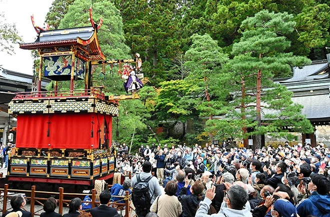 Crowds watching Takayama Autumn Festival floats move through the old town streets