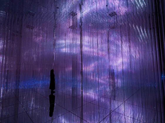 Infinite Crystal World at teamLab Biovortex Kyoto with blue and violet points of light extending through mirrors
