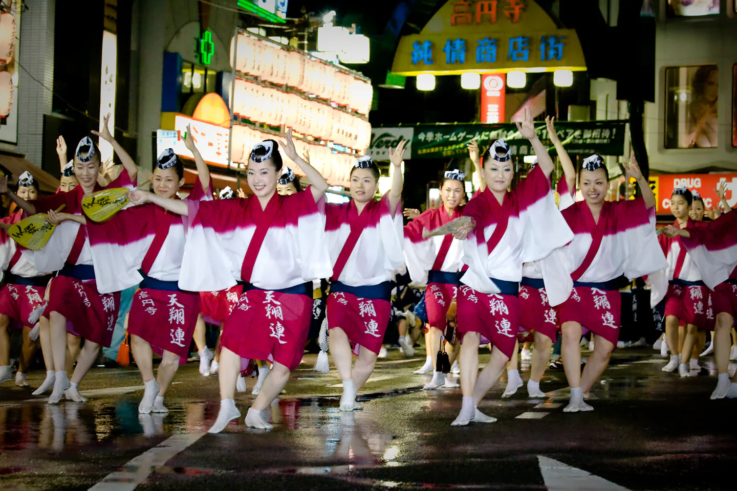 Koenji Awa Odori dancers moving through a crowded Tokyo shopping street